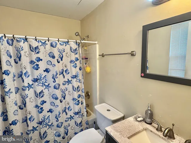 a bathroom with a toilet and a shower curtain