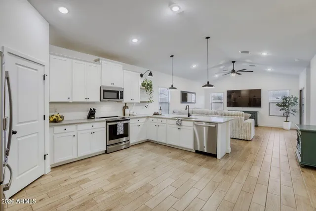 a kitchen with white cabinets and stainless steel appliances