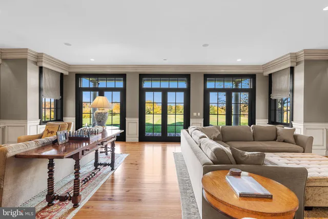 a room with kitchen island a large counter top space a sink stainless steel appliances and cabinets