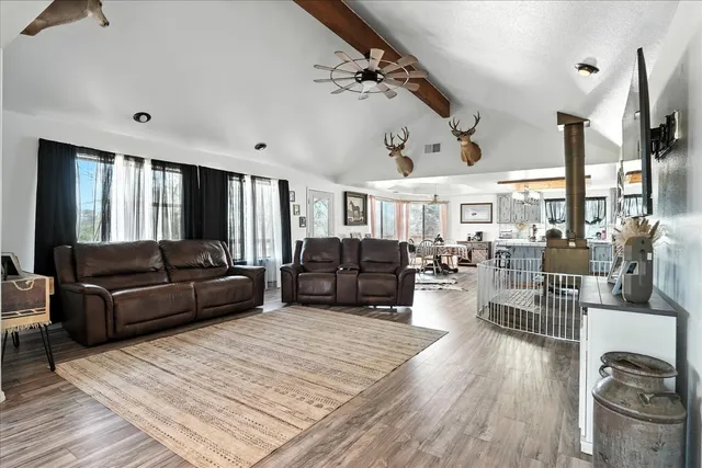 a kitchen with stainless steel appliances granite countertop a table chairs stove refrigerator and cabinets