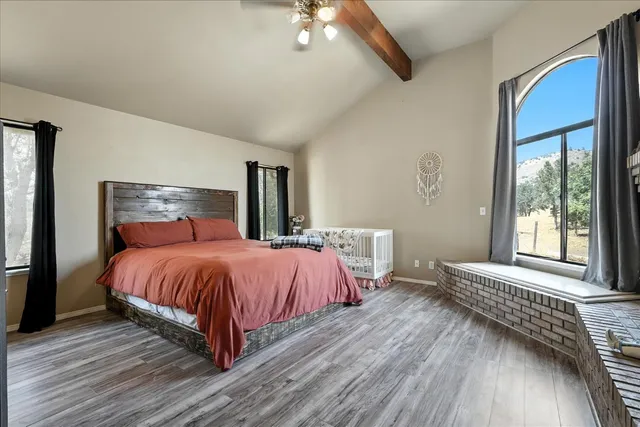a spacious bedroom with a bed and wooden floor
