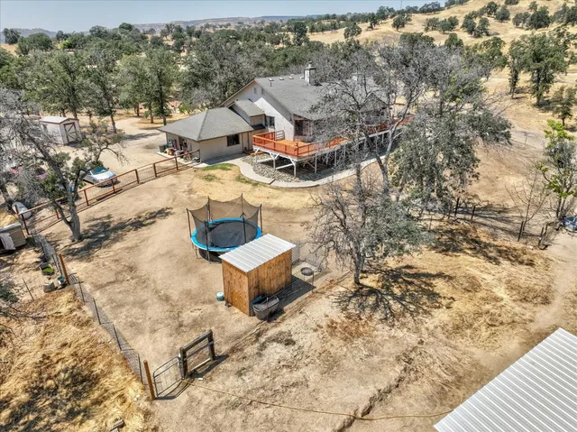 a view of a backyard that has plants and trees with wooden fence