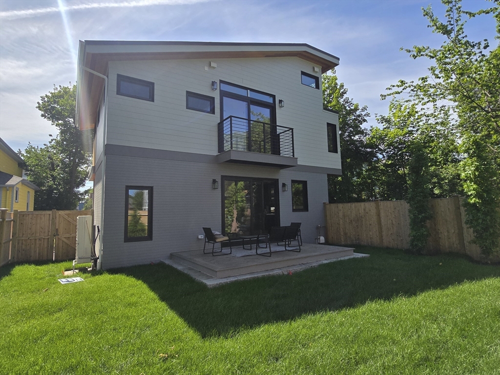 a view of a house with a yard and sitting area