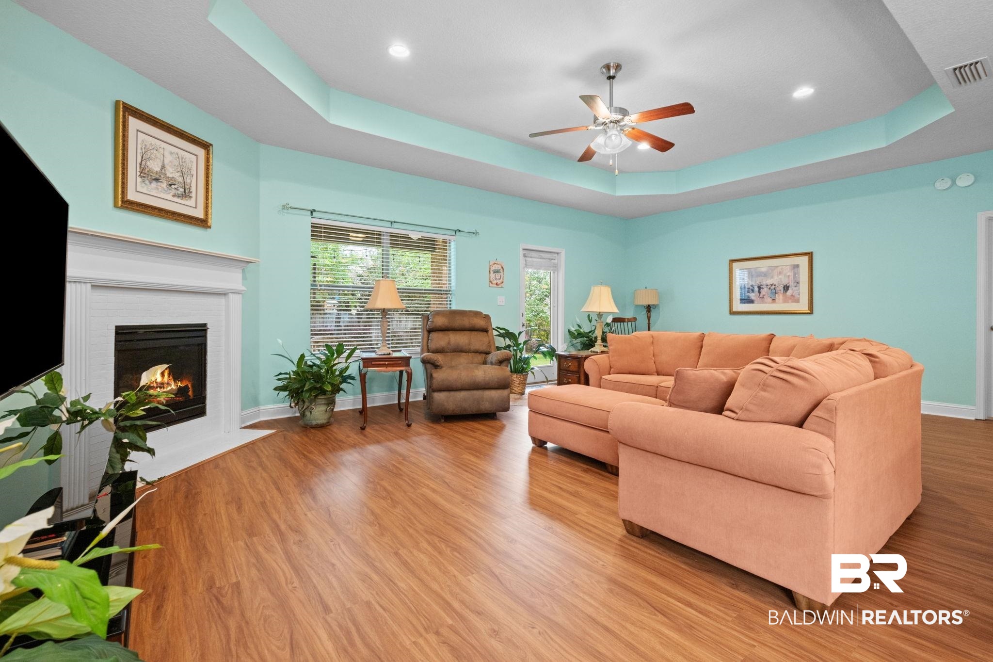 2554 Masters Court Mobile, AL 36618 - Photo 7 of 35 Living area with ceiling fan, a tray ceiling, a fireplace, light wood finished floors, and recessed lighting