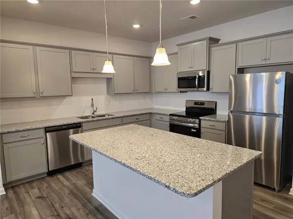 a kitchen with stainless steel appliances granite countertop a sink refrigerator and microwave