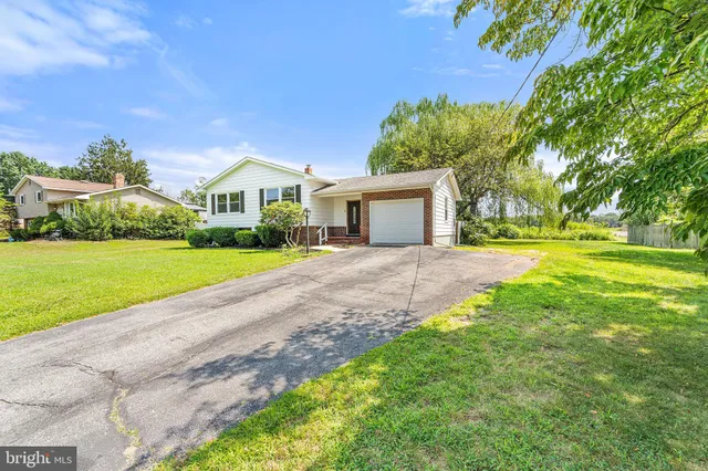 a front view of a house with a yard and potted plants