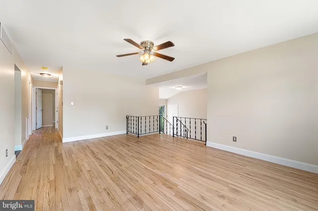 a view of a room with wooden floor and ceiling fan
