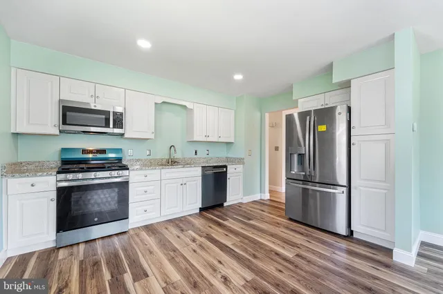 a kitchen with granite countertop a refrigerator stove and microwave