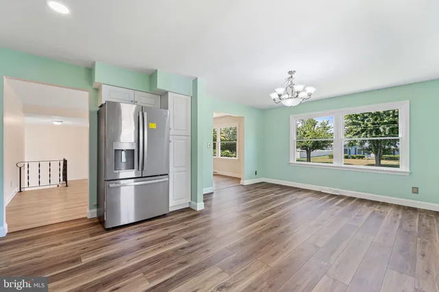 a kitchen with stainless steel appliances a refrigerator and wooden floor
