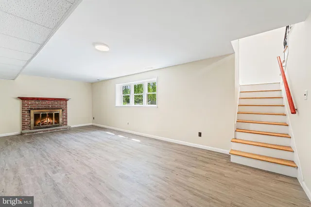a view of empty room with wooden floor and fireplace