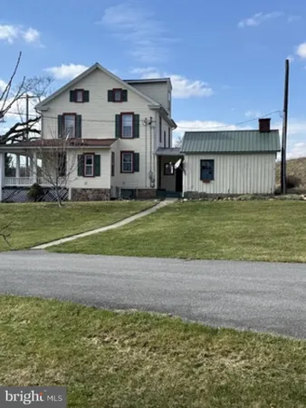 a view of a big house with a yard and large trees