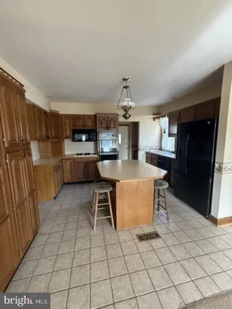 a kitchen with stainless steel appliances kitchen island granite countertop a refrigerator and a stove