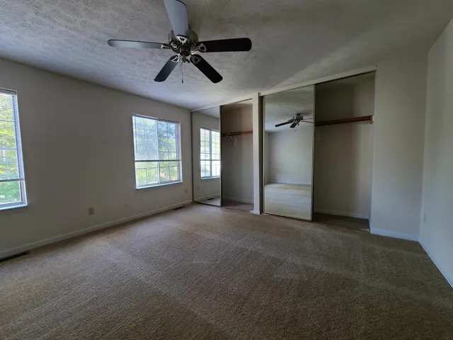 a view of a livingroom with a ceiling fan and window
