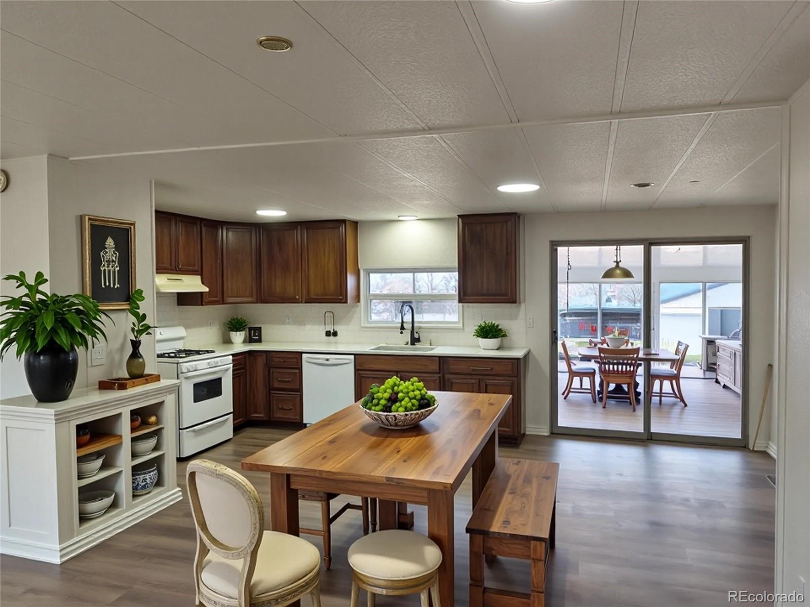 7169 Henry Street Fort Lupton, CO 80621 - Photo 13 of 14 a large kitchen with a table and chairs