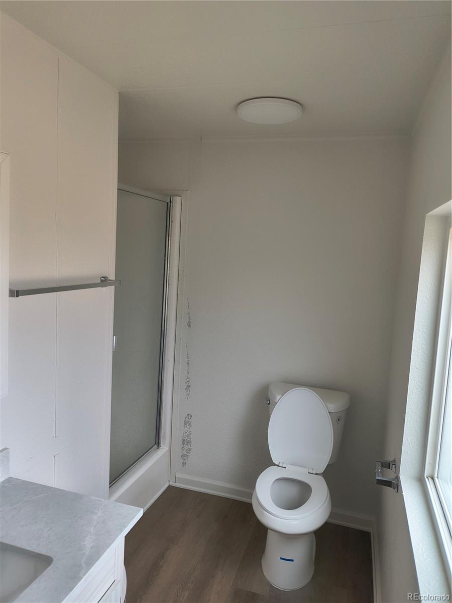 7169 Henry Street Fort Lupton, CO 80621 - Photo 5 of 14 a white toilet sitting next to a bathroom sink