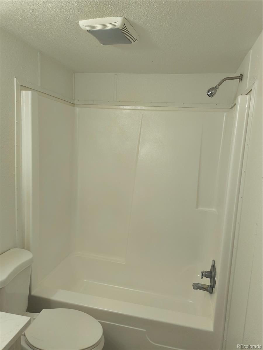7169 Henry Street Fort Lupton, CO 80621 - Photo 6 of 14 a bathroom with a toilet and a shower
