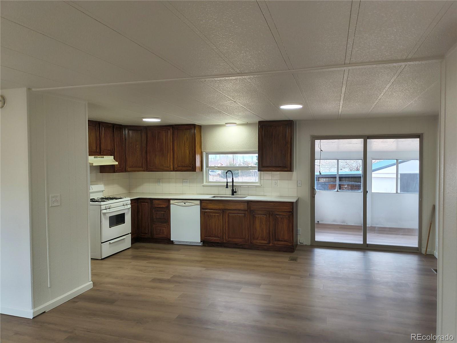7169 Henry Street Fort Lupton, CO 80621 - Photo 9 of 14 a large kitchen with a large counter top space stainless steel appliances and cabinets
