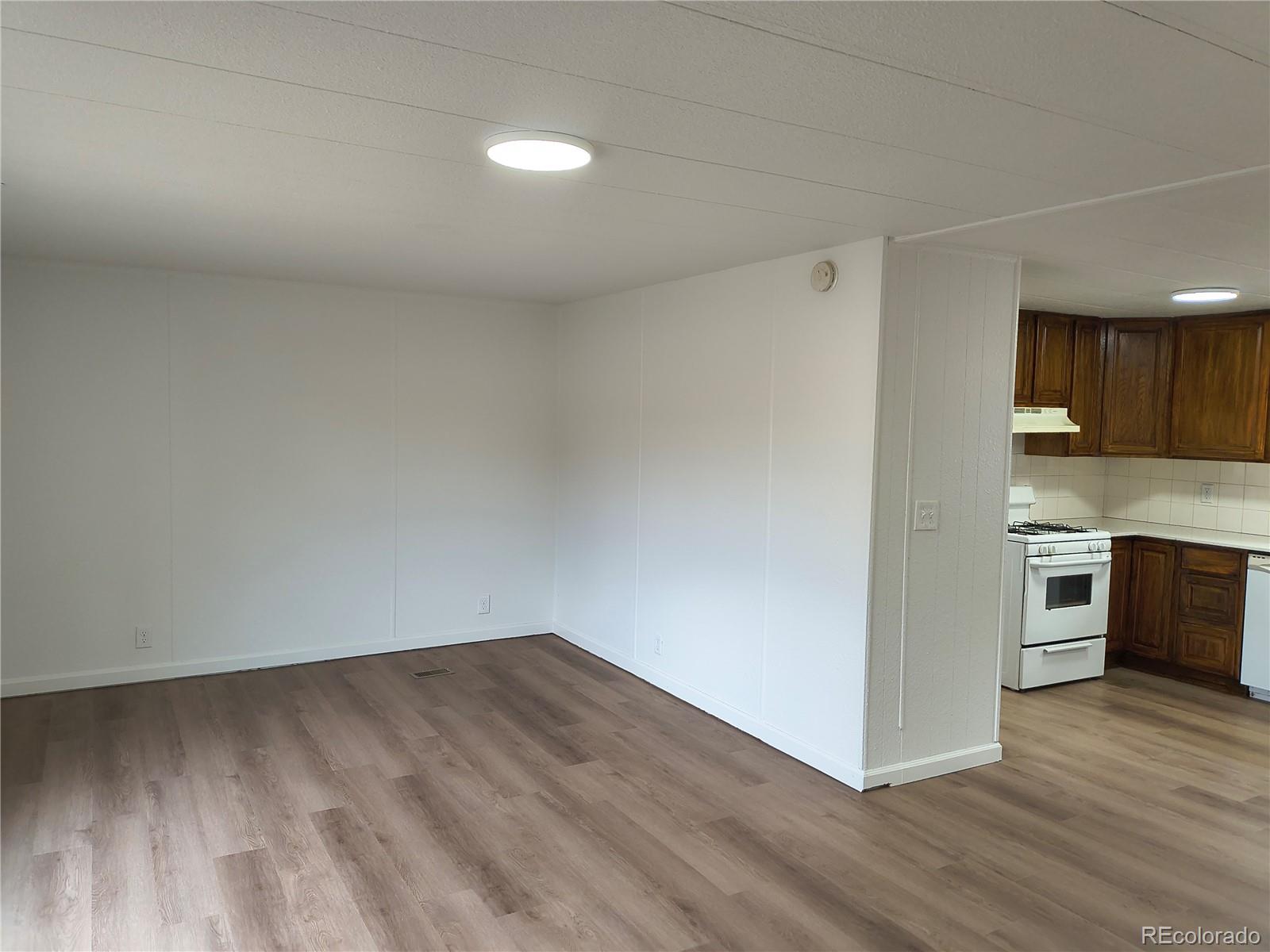 7169 Henry Street Fort Lupton, CO 80621 - Photo 10 of 14 a view of a kitchen with wooden floor and electronic appliances