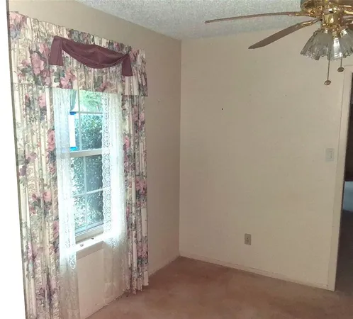 a view of a small space with a chandelier fan