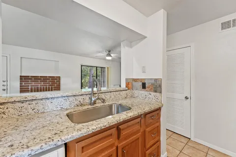 a bathroom with a granite countertop sink and a bathtub