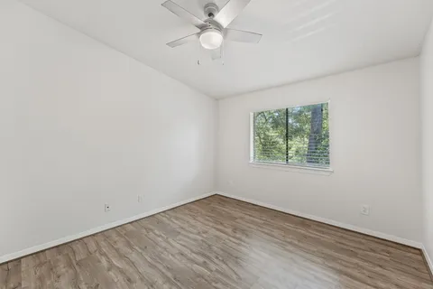an empty room with a window and a fan