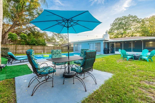 a view of a house with backyard sitting area and garden