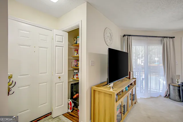 a living room with a flat screen tv and refrigerator