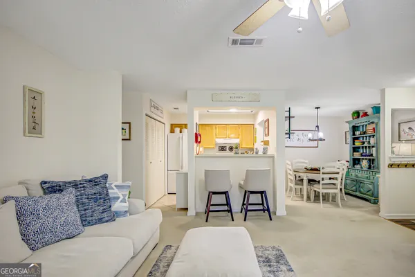 a living room with furniture a dining table and chairs with kitchen view