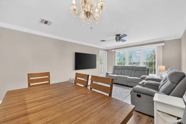 a living room with furniture flat screen tv and a large window