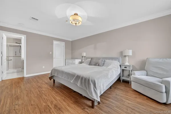 a spacious bedroom with a bed and painting on the wall