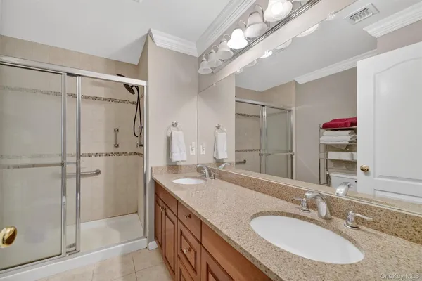 a bathroom with a granite countertop shower sink and mirror