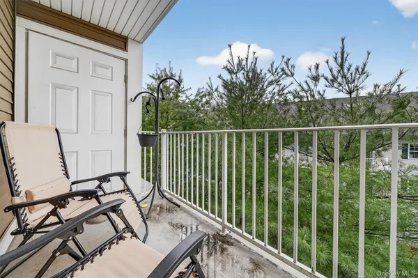 a view of a balcony with chair and wooden floor