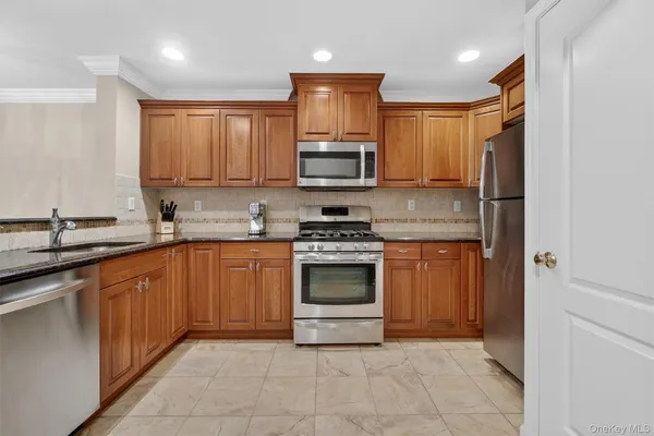 a kitchen with stainless steel appliances granite countertop a stove sink and cabinets