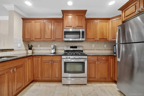 a kitchen with stainless steel appliances granite countertop a refrigerator stove and sink