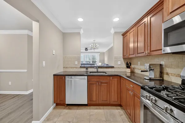a kitchen with stainless steel appliances granite countertop a sink stove and cabinets