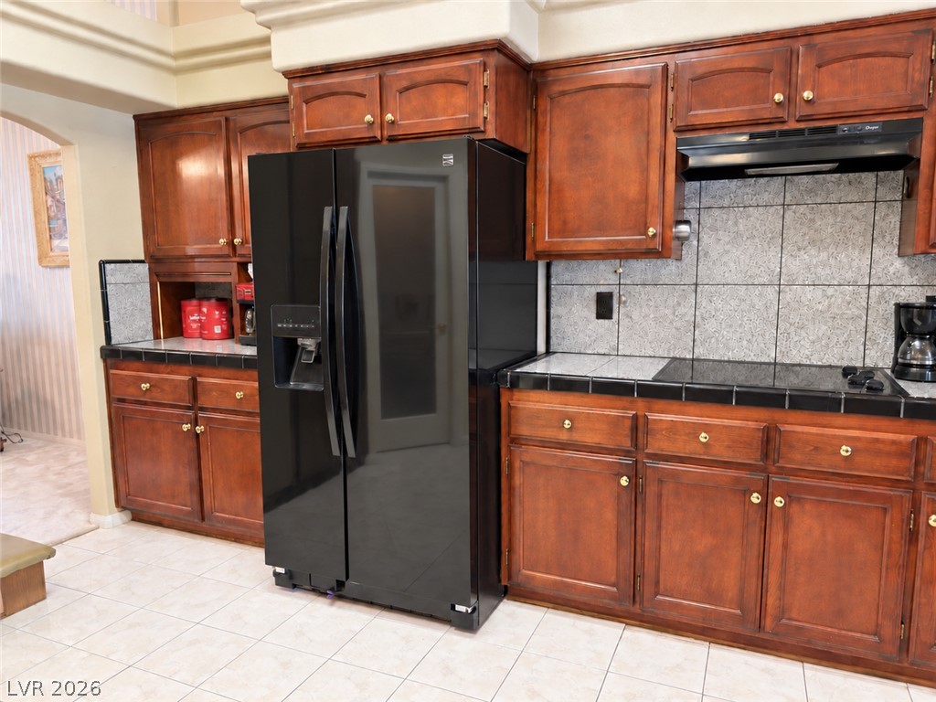 5470 Grain Mill Road Pahrump, NV 89061 - Photo 12 of 80 Rich wood cabinetry and classic tile flooring define this functional kitchen workspace.