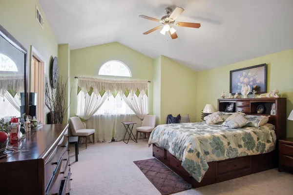 a bedroom with a bed gym equipment and a large window