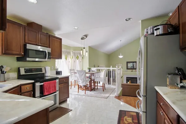 a living room with stainless steel appliances furniture a kitchen view living room and a microwave