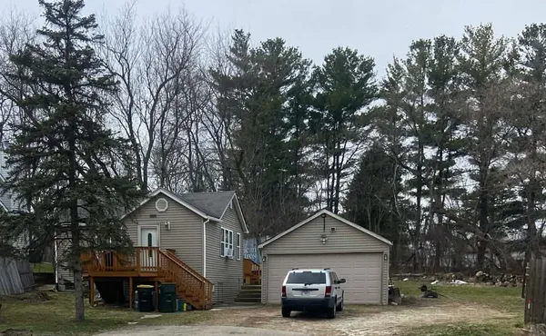 a front view of a house with parking space and trees