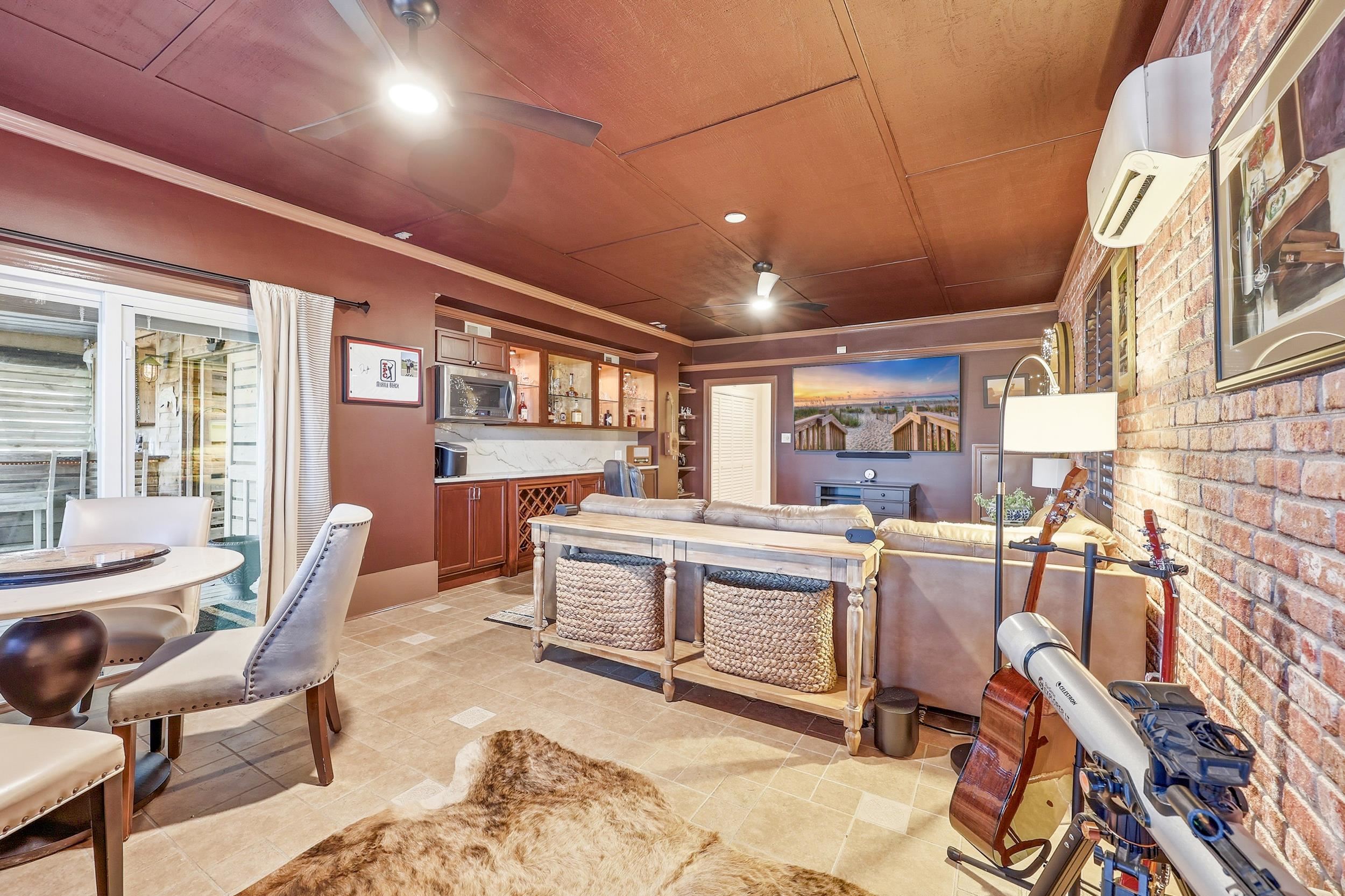 46 High Hammock Way Pawleys Island, SC 29585 - Photo 23 of 40 Interior space with a wall unit AC, a ceiling fan, brick wall, wood ceiling, and ornamental molding