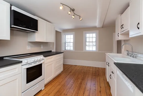 a kitchen with a sink stove and microwave