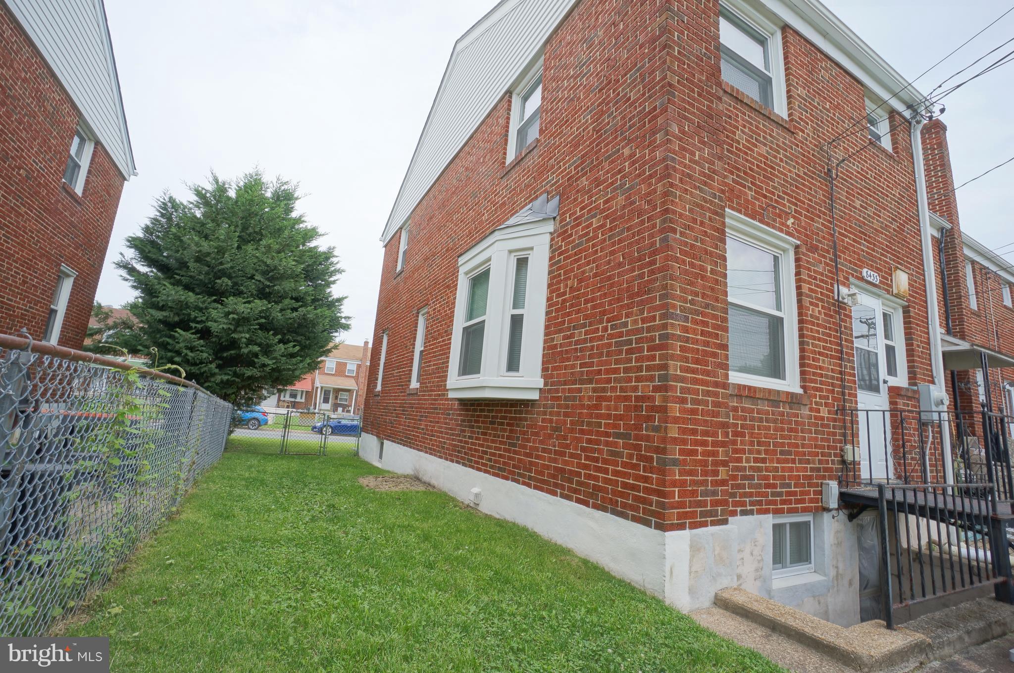 8433 Kavanagh Road Baltimore, MD 21222 - Photo 22 of 23 a view of a brick building next to a yard