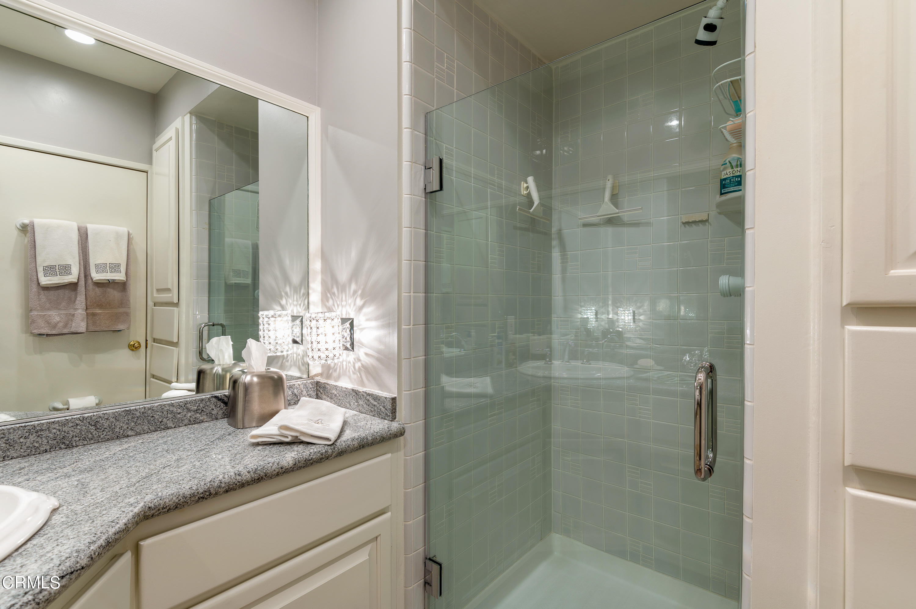3894 San Augustine Drive Glendale, CA 91206 - Photo 26 of 51 a bathroom with a granite countertop sink a mirror and a shower