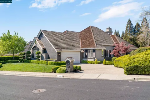 a front view of a house with a yard and potted plants