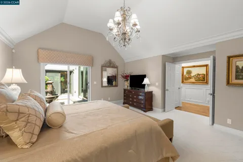 a spacious bedroom with a bed and a flat screen tv