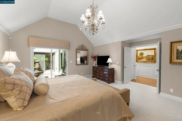 a spacious bedroom with a bed and a flat screen tv