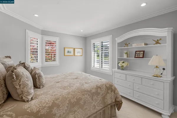 a bedroom with a bed a dresser and next to a window