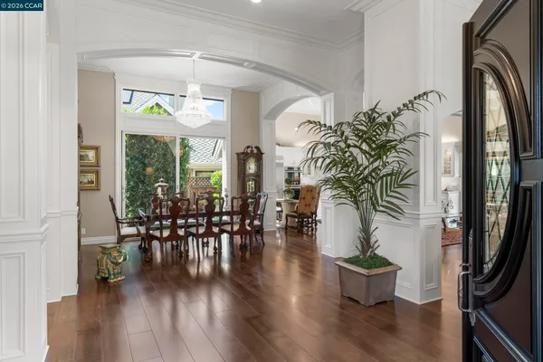 an entryway with wooden floor and a potted plant