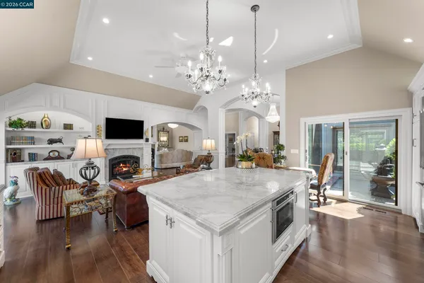 a open kitchen with stainless steel appliances granite countertop a stove oven a dining table and chairs with wooden floor