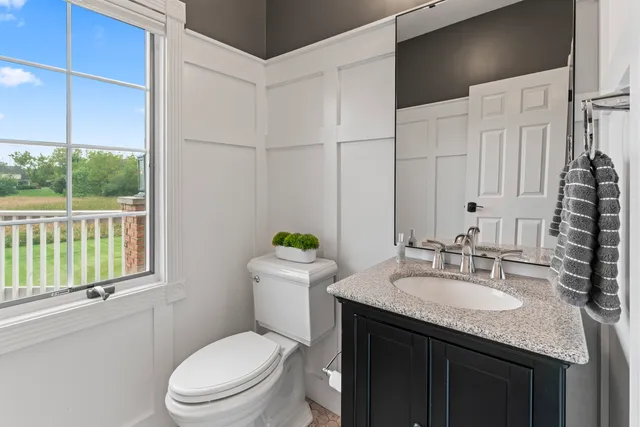 a bathroom with a double vanity sink toilet and mirror